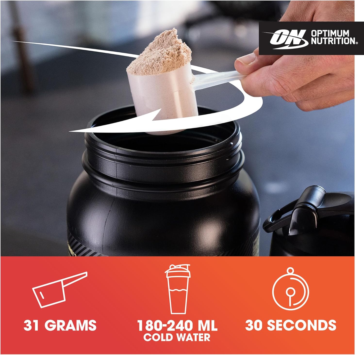 Person pouring a scoop of protein powder into a shaker bottle with Optimum Nutrition branding.