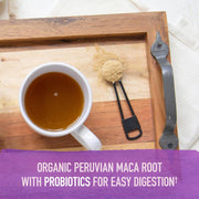 Teaspoon of maca powder being added to a cup.