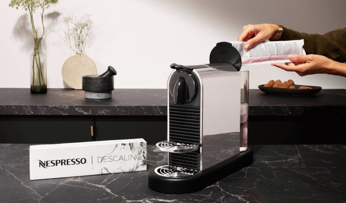 Nespresso descaling kit shown next to a compatible Krups or Magimix machine.