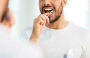 Lifestyle/use image: Pristine Gleam medium toothbrush daily oral care plastic handle nylon bristles 4 pack